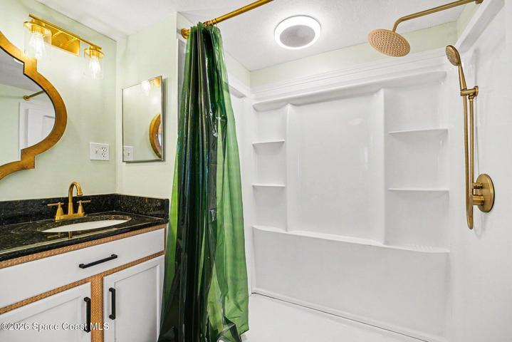 Fiberglass Shower with Build-In Shelving, Gold Hardware, and Updated Lighting