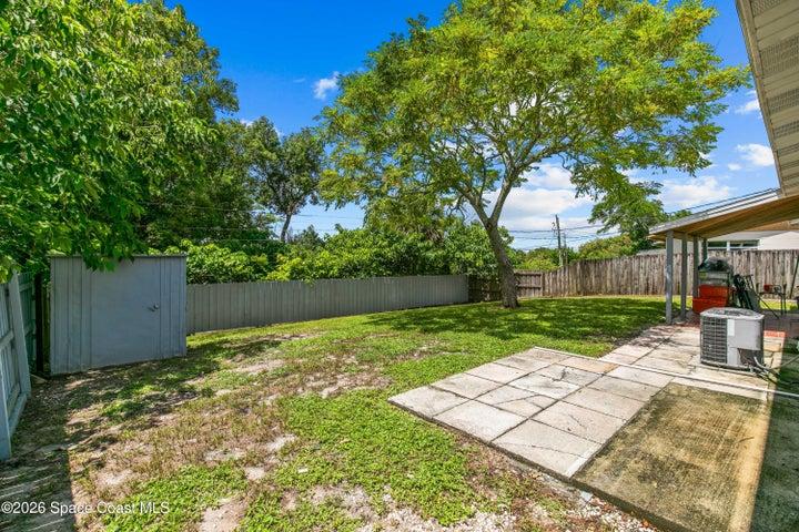 Fenced Backyard Overlooking Shed and Mature Trees