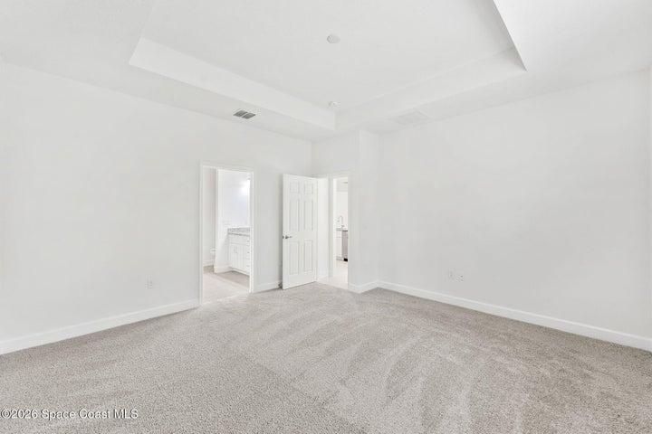 The Primary Bedroom features its own tray ceiling and carpet for added comfort.