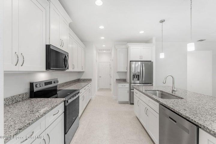 This upgraded home features Granite Countertops, stainless steel appliances, an oversized island, and luxury four door refrigerator.