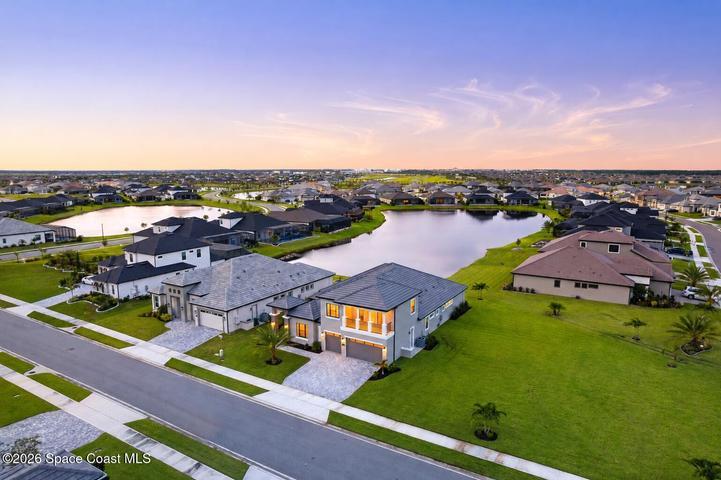 Bird’s-eye view highlighting the home, driveway, and surrounding landscape.