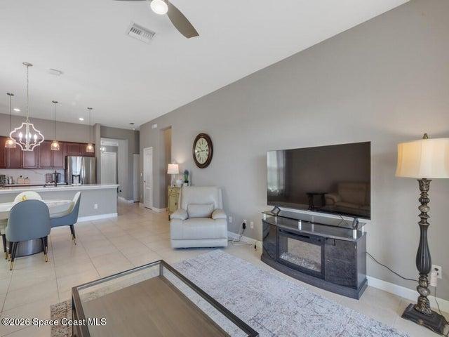 Open-concept living space with light neutral wall tones and tile flooring throughout
