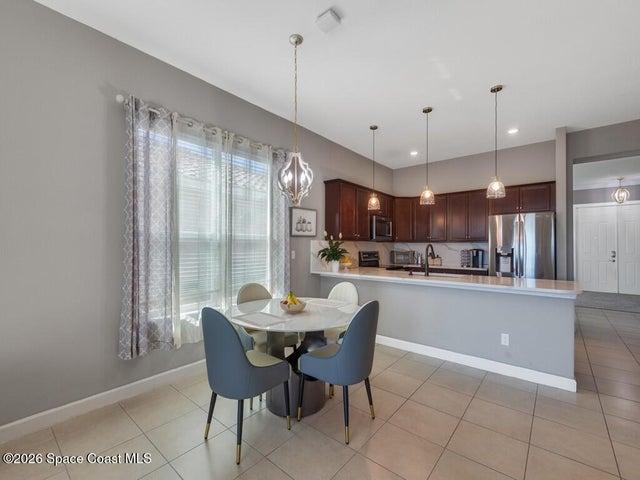 Kitchen area featuring dark wood cabinetry, stainless steel appliances, and a light-toned countertop