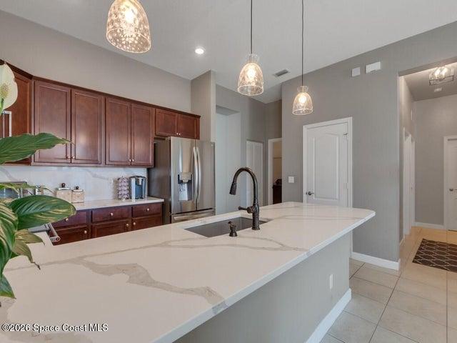 Kitchen featuring a large central island with an undermount sink and matte black faucet