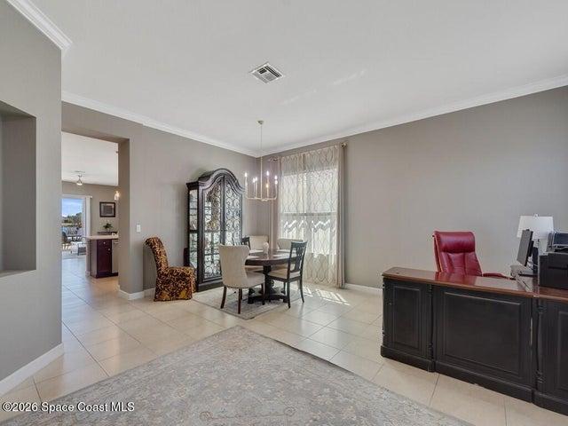 Spacious interior with tile flooring and crown molding