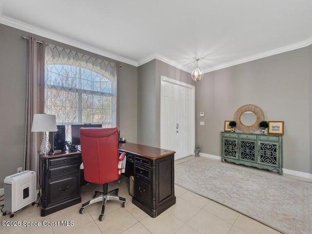 Entryway featuring a double-paneled door, crown molding, and light-toned tile flooring