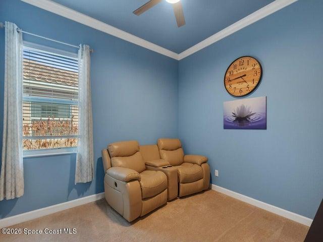 Room featuring crown molding, neutral carpeting, and a window with blinds
