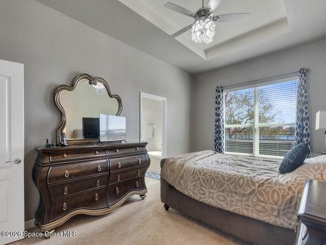 Spacious room featuring a tray ceiling, recessed lighting, and a crystal chandelier fan