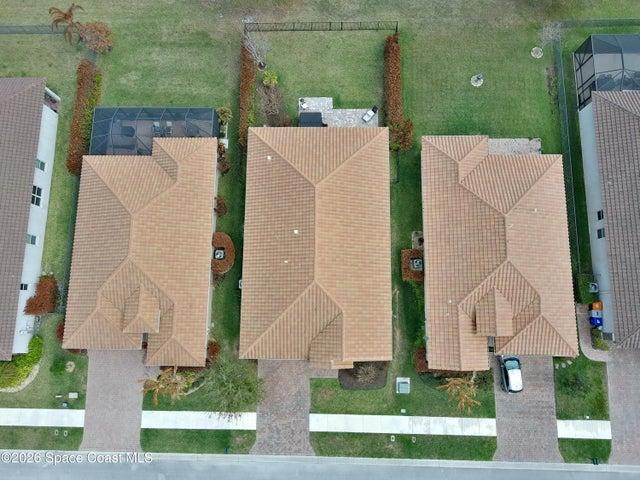 Aerial perspective showcasing three properties with tile roofs