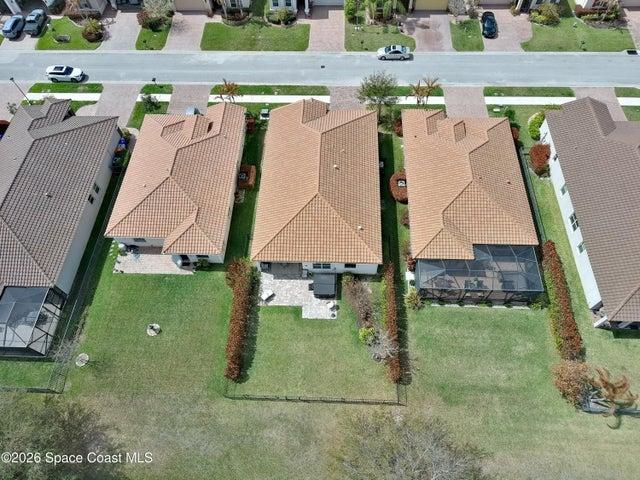 Aerial perspective showcasing three properties with tile roofs