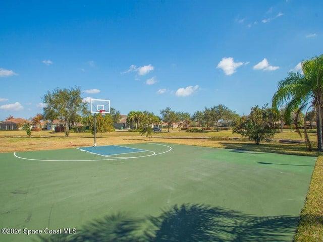 Multi-court facility featuring blue and green hard courts, white court lines, and black chain-link fencing