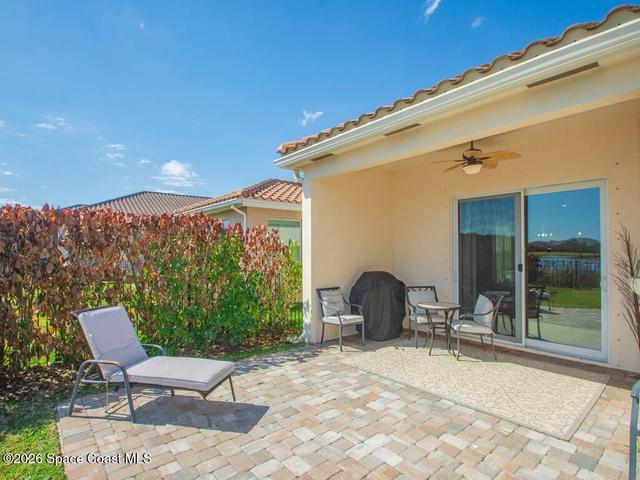 Covered patio featuring a ceiling fan, sliding glass doors, and a decorative outdoor rug