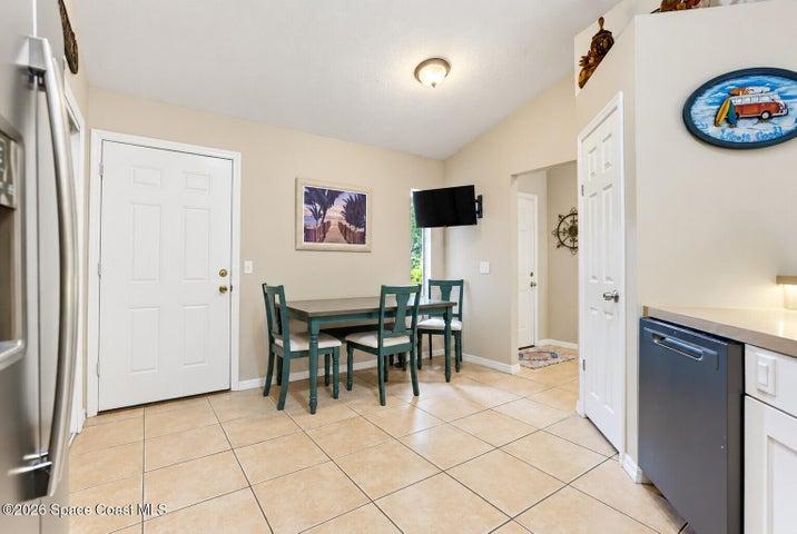 Sloped ceiling, recessed lighting, tile flooring, built-in dishwasher, and a paneled refrigerator