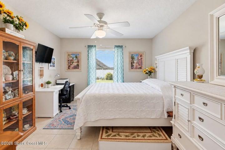 Tile flooring, built-in desk, window with blinds, ceiling fan with light fixture
