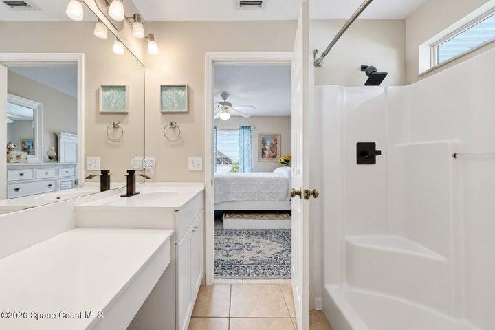Vanity with white countertops, integrated sinks, and dark bronze fixtures