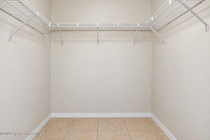 Built-in wire shelving, neutral wall paint, and square floor tiles