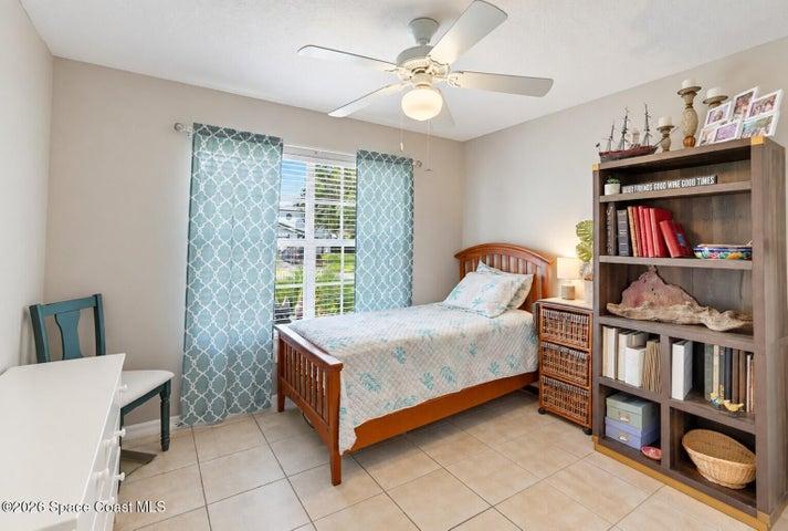Recessed window with blinds, overhead ceiling fan with lighting, and light-toned tile flooring