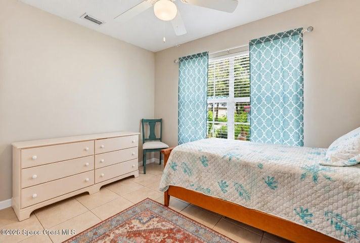 Ceiling fan with light fixture, window with blinds, tile flooring, and neutral wall paint