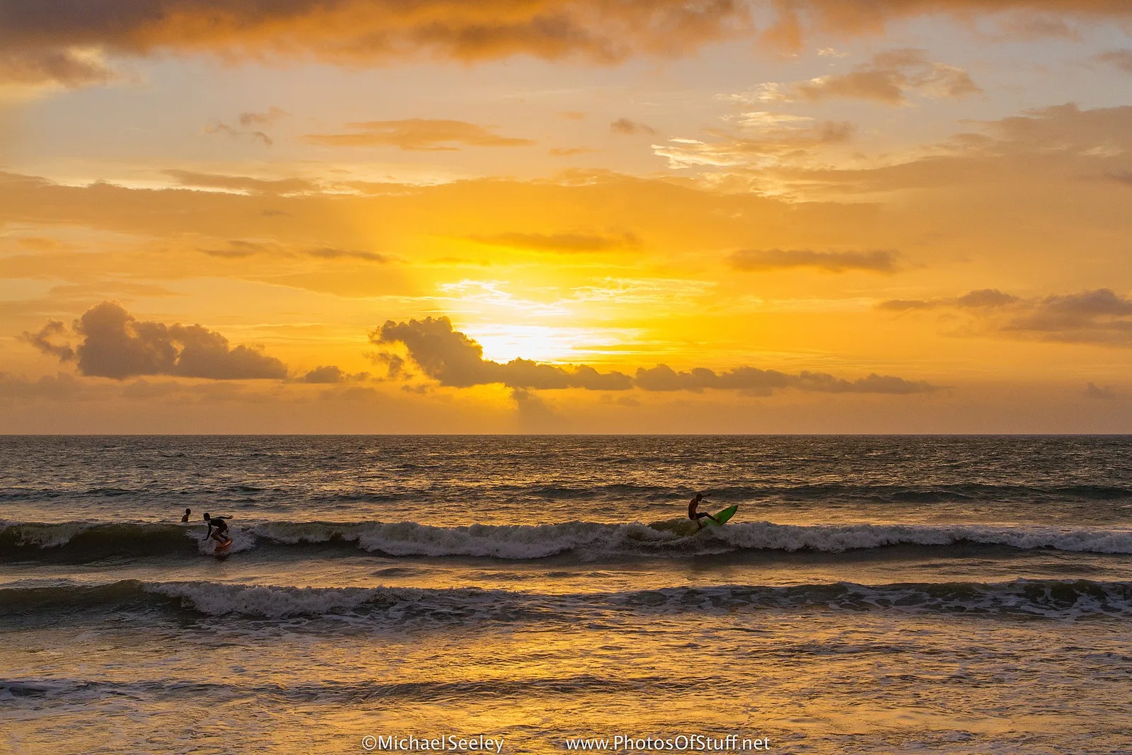 Surfers in golden sunrise light at Satellite Beach